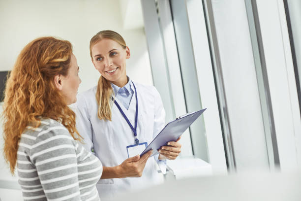 젊은 의사가 환자를 보고 하면서 클립보드를 들고 - medical visit 뉴스 사진 이미지