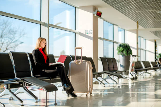 istock Young woman using a laptop in an airport 1125664554