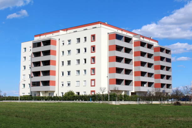 istock Newly built modern apartment building with multiple apartments and balconies surrounded with grass and small hedge 1125665910