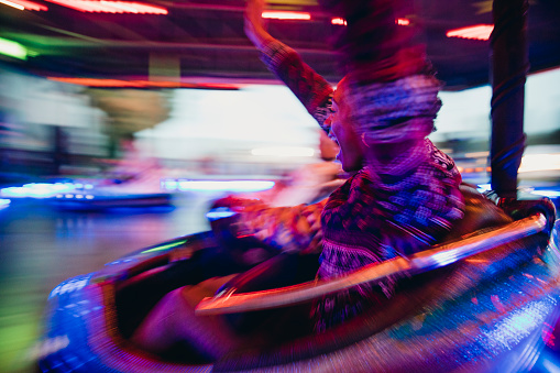 Blurred motion shot of a teenage girl on the dodgems.