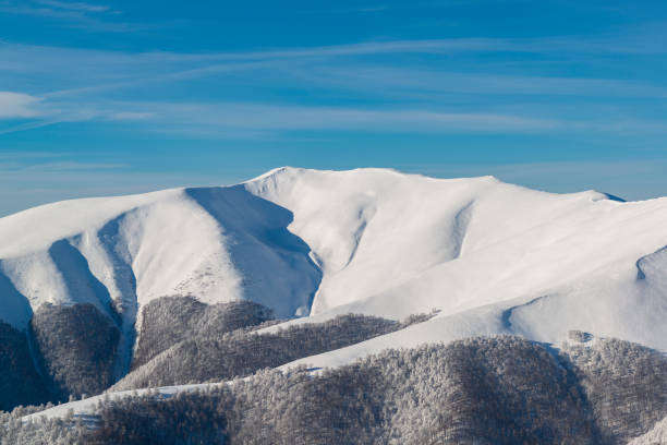 cresta de montaña cubierto de nieve en invierno. cerros peligrosos aludes - alp descent fotografías e imágenes de stock