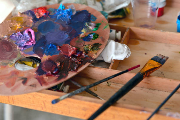istock Wooden palette with oil paints on a camp easel 1125673361