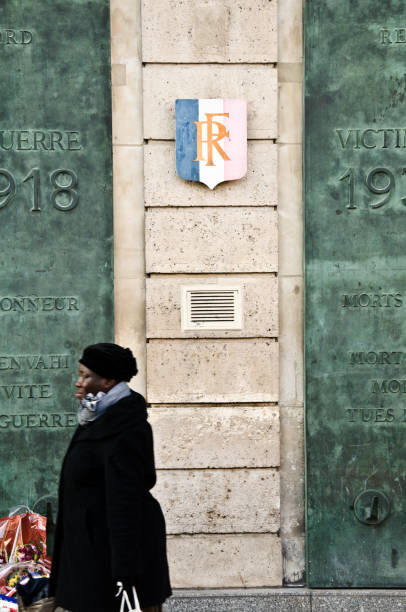 weibliche fußgänger (tourist) vorbei an einer gedenktafel (gegenüber dem sncf-bahnhof gare du nord, paris, île-de-france). in erinnerung an 1210 eisenbahner aus paris nordbahnhof, opfer des ersten weltkrieges in der schlacht, nach der deportation und w - île de stock-fotos und bilder