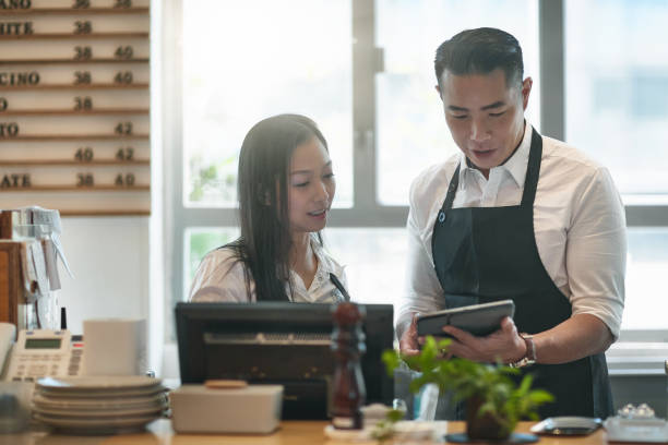 istock Mature baristas discussing over digital tablet 1125677257