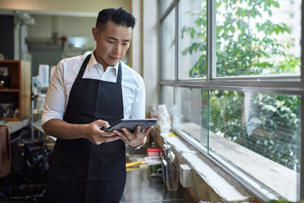 istock Male barista using digital tablet at coffee shop 1125677510