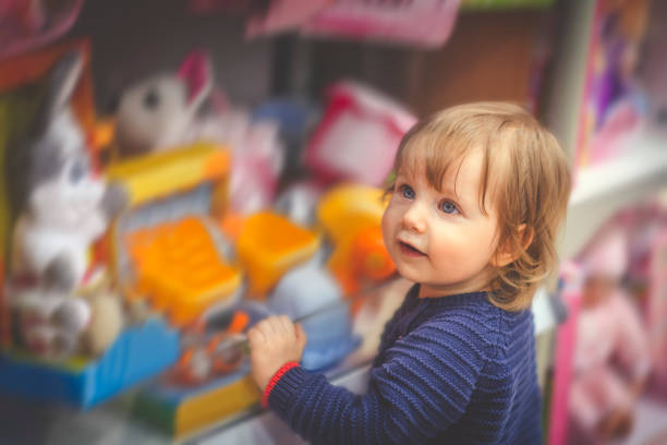 Happy little boy choosing toy in a store Cute child in toy store toy store stock pictures, royalty-free photos & images