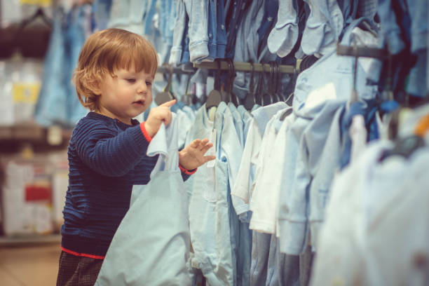 istock Cute little boy choosing blue clothes during shopping 1125679091