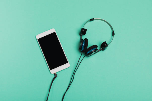 istock Top view mobile phone and headphones on blue background with copy space. 1125679229