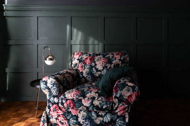 istock Cozy living room corner with flora pattern fabric armchair setting with black wood side table and gold mirror table lamp on green paint pattern paint wall / urban green concept 1125679432
