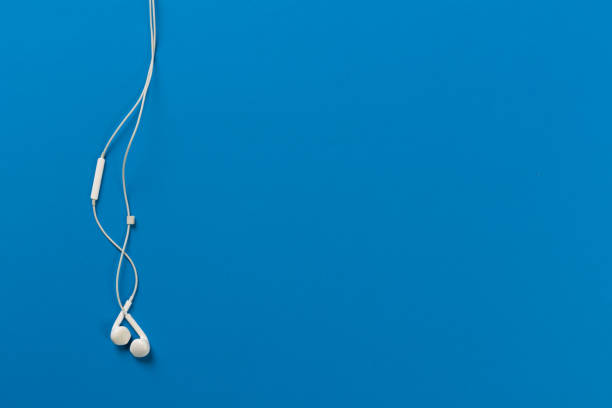 istock White earphones on blue background 1125680076