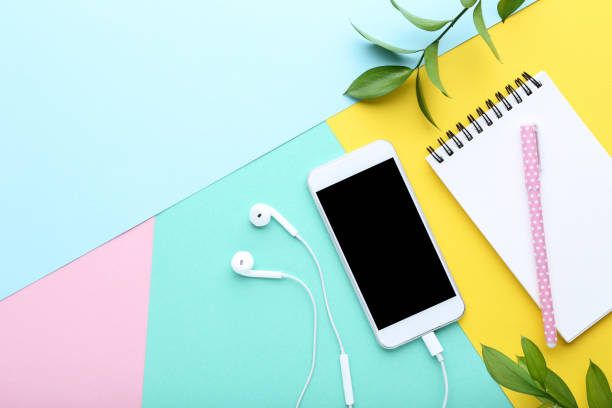 istock Smartphone with earphones and notebook on colorful background 1125681270