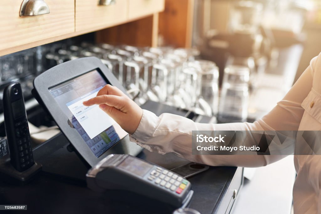 Are you ready for the bill? Shot of an unrecognizable woman punching in a order for a customer Point Of Sale Stock Photo