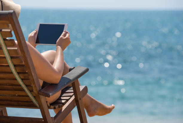 istock Blank empty tablet computer in the hands of women on the beach 1125684489
