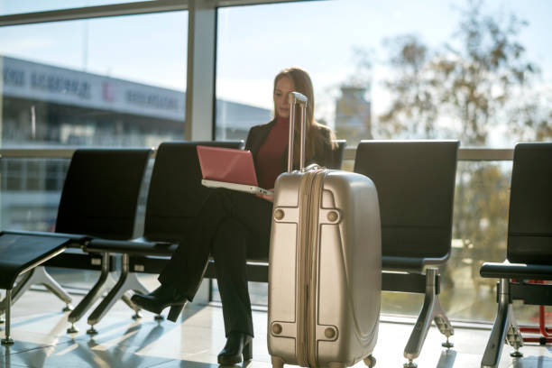 istock Young woman using a laptop in an airport 1125685848
