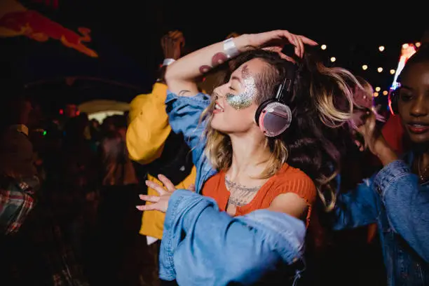 Young woman is dancing with her friends in a silent disco.