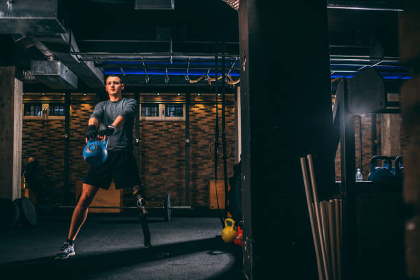 istock Adaptive young athlete with a leg prosthetic training with kettlebell in a gym gym 1125688078