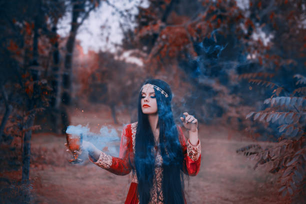 istock mysterious witch from the west creates a love potion, magical rite to call upon spirits and deities, souls from the afterlife, girl with black long hair with a silver ornament in a bright red dress 1125688225