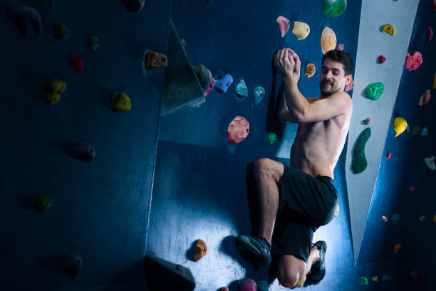 istock Muscle man male climbing bouldering in training hall 1125689275