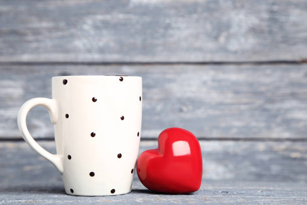 istock Red heart with cup on gray wooden table 1125689908