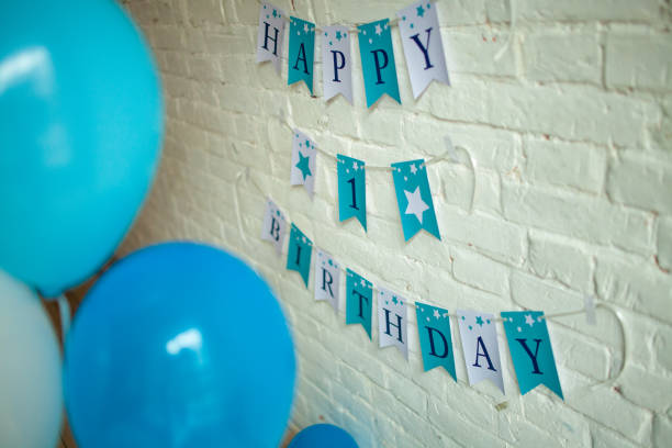 istock Decorations for one year birthday with blue balloons and inscriptions on wall. 1125690443