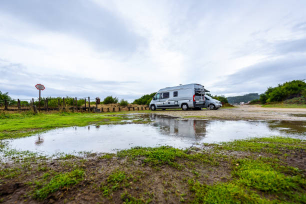 istock Campervan or motorhome camping on rainy day with rain puddles. 1125691573