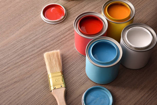 istock Assortment of open paint cans and brush on table top 1125691592