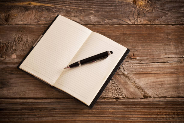 istock notebook with pen  on old  wooden table 1125692084