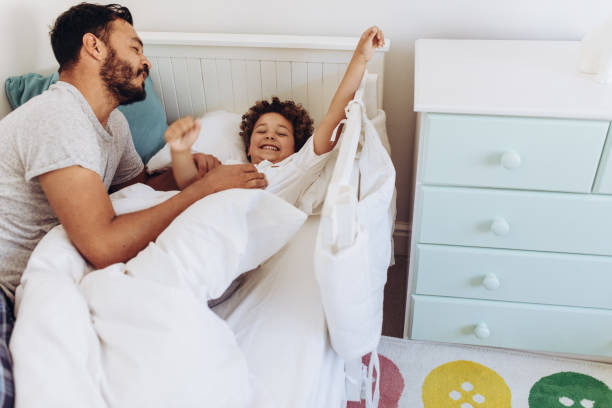 istock Father and son on bed waking up 1125694213