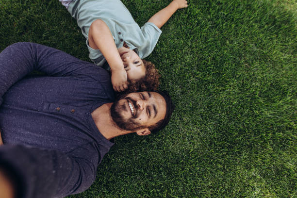 istock Father and son relaxing in a park lying on ground 1125694276