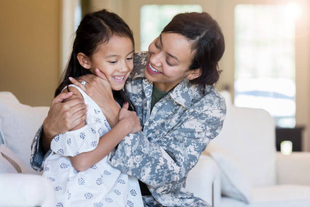 istock Mom in uniform talks with elementary age daughter 1125694545