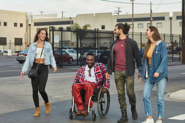 istock Friends walking with disabled man on street 1125696881