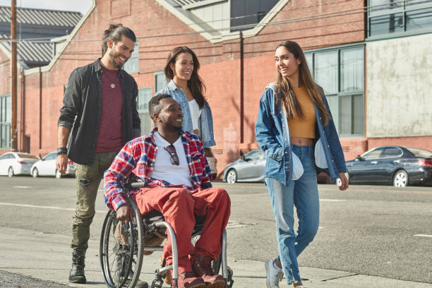 istock Diverse people walking with disabled man on street 1125697571