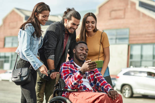 istock Disabled man with friends using phone in city 1125697913