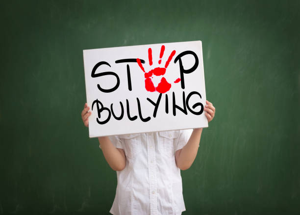 Violence in today schools Boy holding a sign with red palm print and text stop bullying former yugoslavia stock pictures, royalty-free photos & images