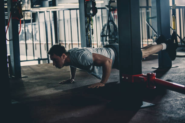istock Man having suspension training in the gym 1125700639