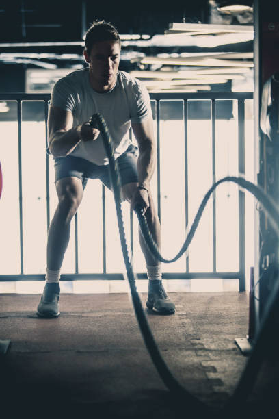 istock Man doing battle rope training in the gym 1125700909