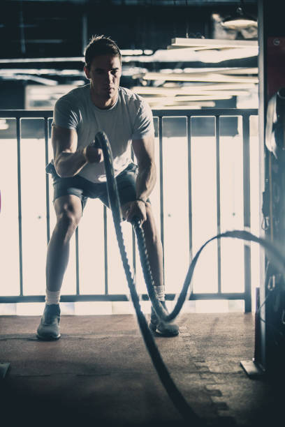 istock Man doing battle rope training in the gym 1125700914