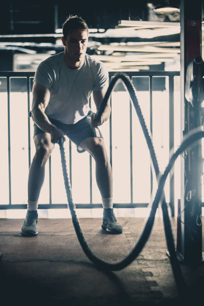 istock Man doing battle rope training in the gym 1125700919