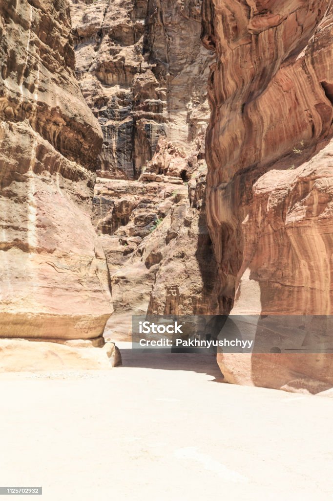 The Siq, the narrow slot-canyon The Siq, the narrow slot-canyon that serves as the entrance passage to the hidden city of Petra, Jordan, Ancient Stock Photo