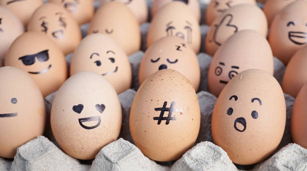 easter eggs with selective focus on the hashtag sign (#) surrounded with the emojis. emoji is expression stickers used in the chat application & social media. emoji is trend of 2019. - egg cell imagens e fotografias de stock