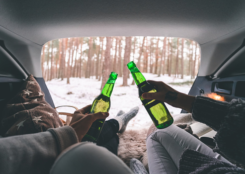 Personal perspective of a couple on a cozy picnic in the trunk of a car during winter.