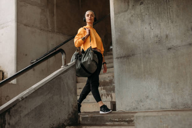 athlète féminine à pied à l’intérieur d’un stade - gym bag photos et images de collection