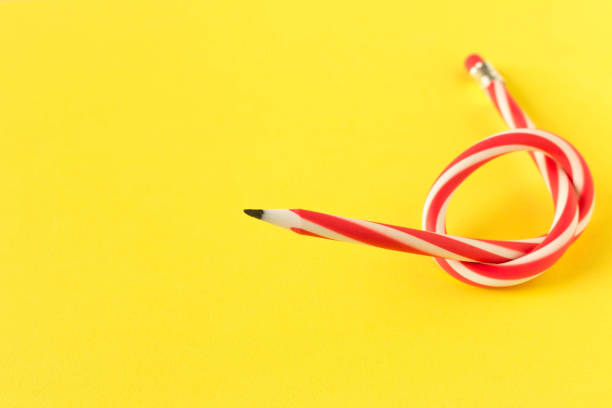 istock Red and white flexible pencil. Isolated on yellow background. 1125707245
