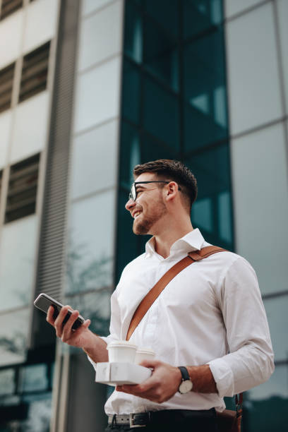 istock Businessman going to office holding mobile phone and coffee 1125707328