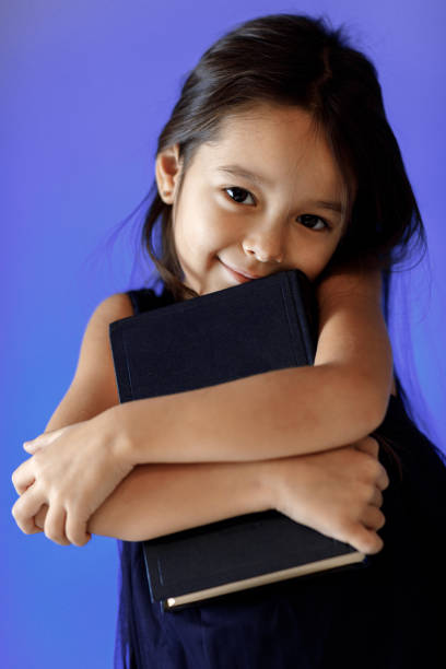 istock cute little girl is reading a book. 1125708662