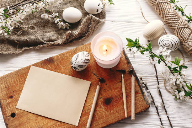 istock stylish painted easter egg black and white colors at rustic wooden background with spring flowers and candle. happy easter greeting card. modern easter eggs top view. holiday traditions 1125708898