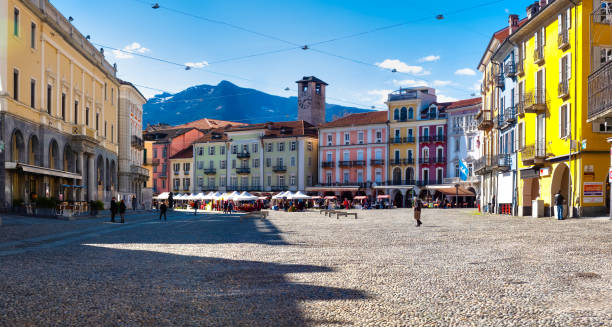 locarno, switzerland - piazza grande is the main square of locarno. in the picture we see the old houses and people walking around the square. the weekly market  takes place every thursday. - locarno imagens e fotografias de stock