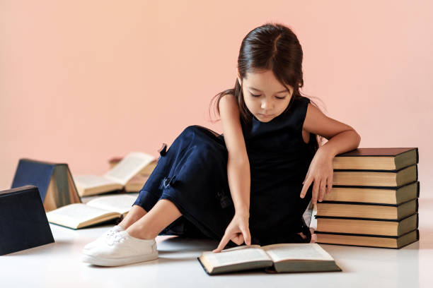 istock cute little girl is reading a book. 1125709087