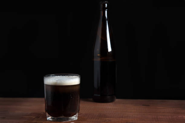 istock dark beer with foam in a glass on a wooden table 1125712633