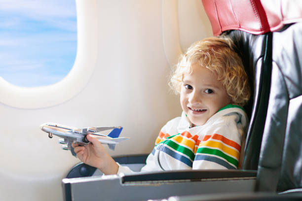 istock Child flying in airplane. Flight with kids. 1125714447
